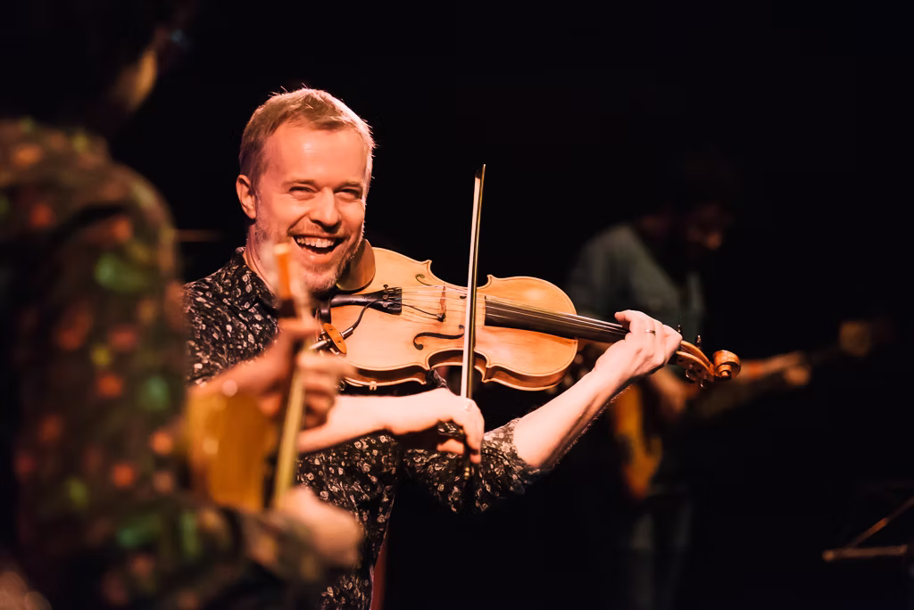 Nicolas Krassik com violino, representando fluência na improvisação brasileira.